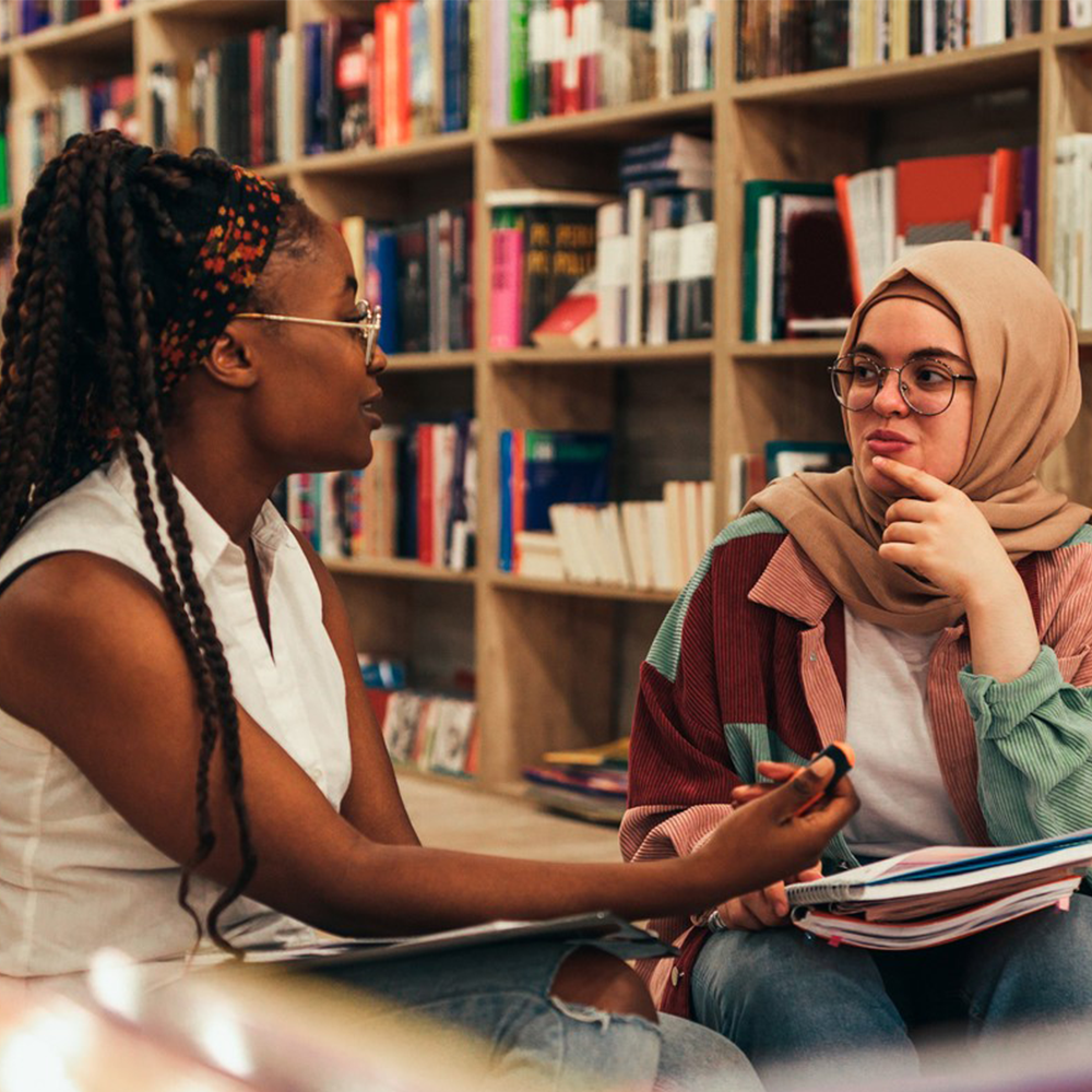 Two women talking in a library